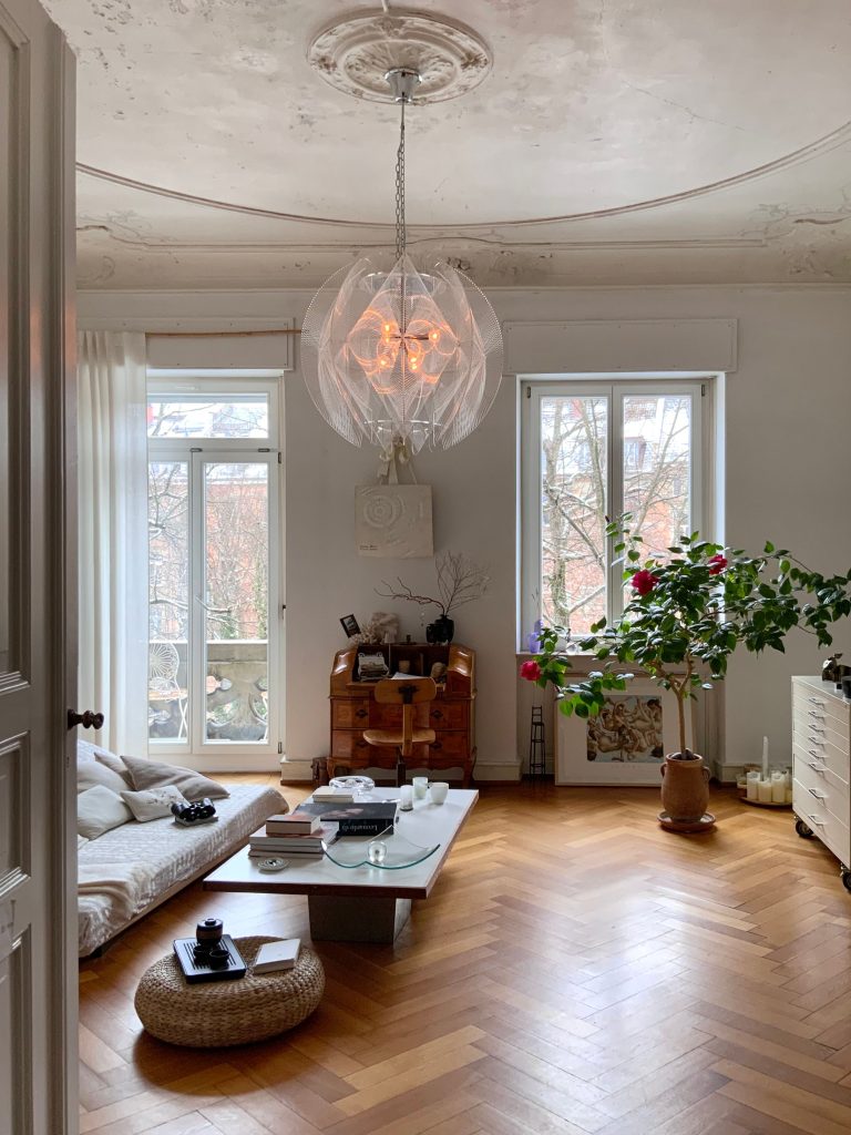 Stylish living room with minimalist decor, parquet flooring, and ample natural light.